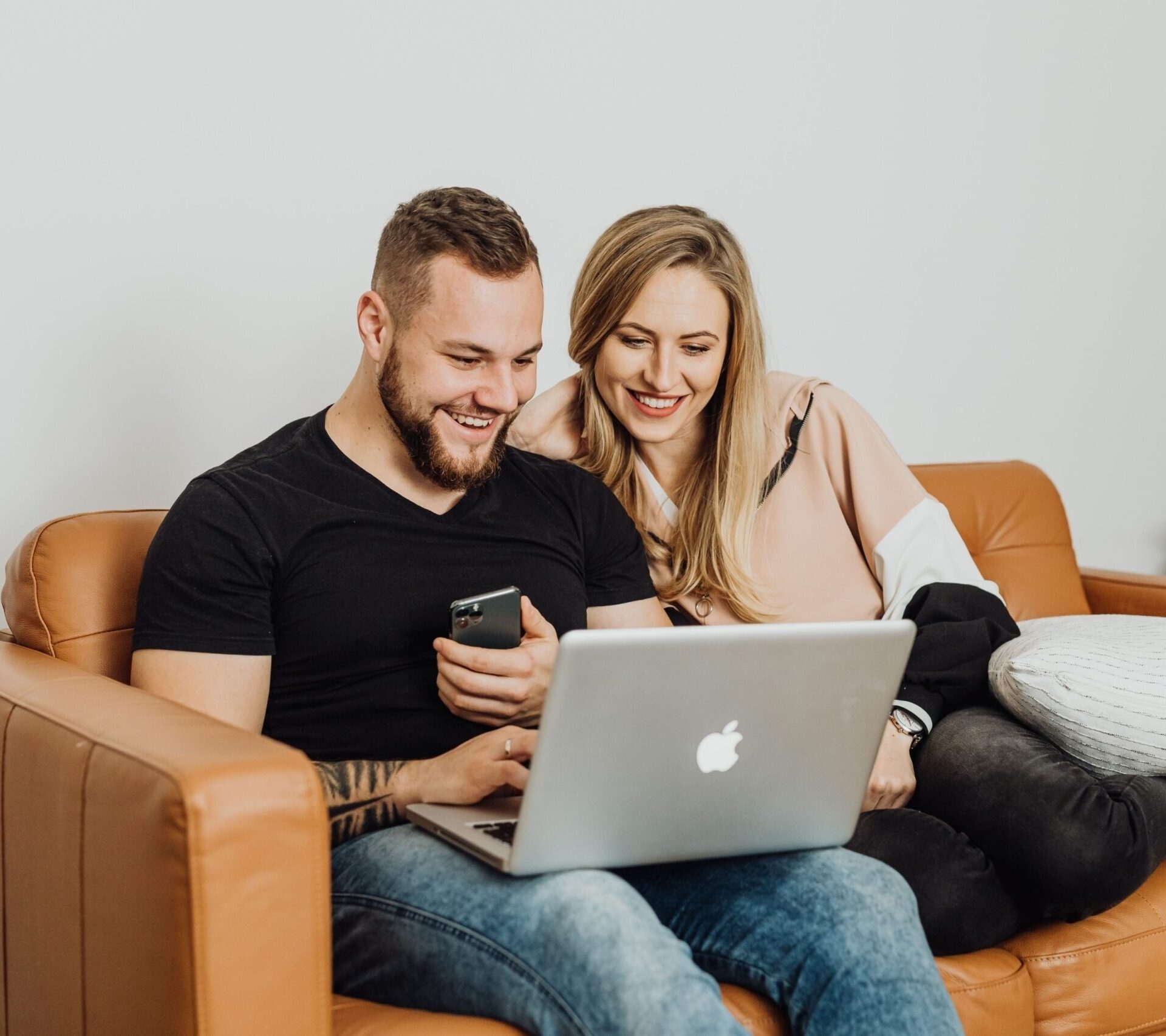 Happy couple completing an application on the computer